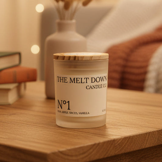 Candle jar labeled 'The Melt Down Candle Co.' on a wooden surface