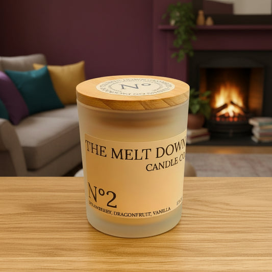 Candle jar labeled 'The Melt Down' on a wooden surface with a blurred background